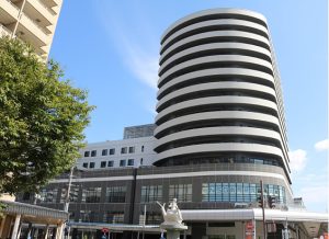 円形の独特な建築デザインを持つ介護施設の建物外観。明るい晴天下での撮影。