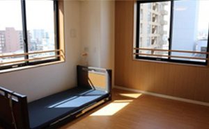 採光良好な居室。ベッドと窓からの眺望が確認できます。